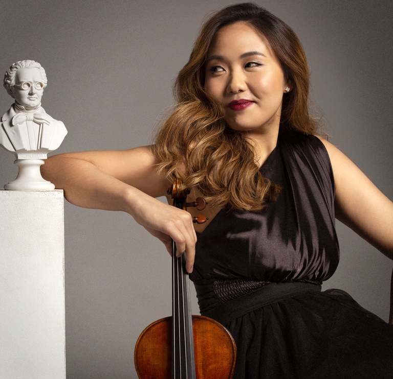 Stella Chen with her violin beside a bust of Schubert